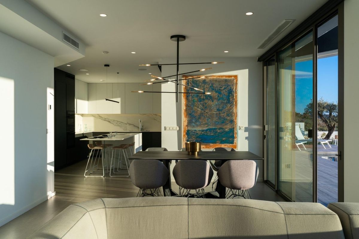 Stylish dining area and open kitchen in the villa, featuring contemporary design and scenic views.