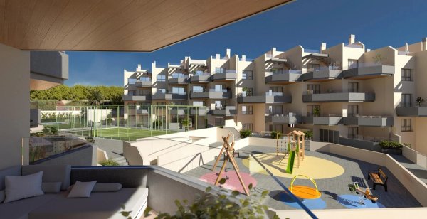 Uitzicht vanaf het terras op de speeltuin en gemeenschappelijke ruimte in een modern appartementencomplex in Torrox, Costa del Sol.
