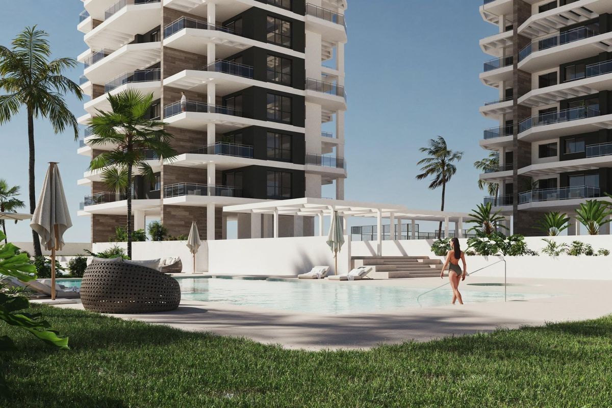 Ontspannend zwembadgebied met ligstoelen en palmbomen, ideaal om te zonnebaden in dit appartementencomplex in Calpe.