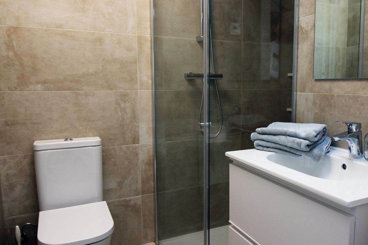 Moderne badkamer met een glazen douche en strakke lijnen in de tussenwoning gelegen in Pilar de La Horadada.