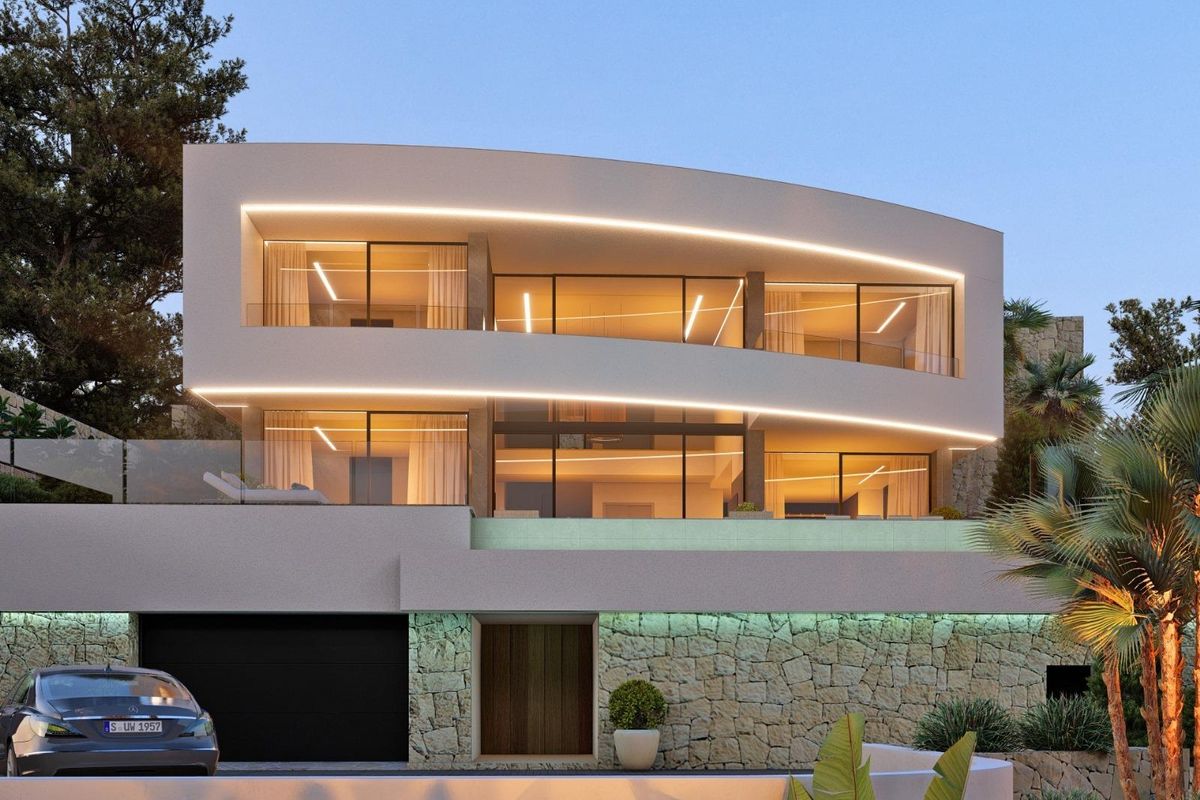 De elegante buitenkant van een hedendaagse villa in Calpe, verlicht in de schemering, die het strakke ontwerp toont.