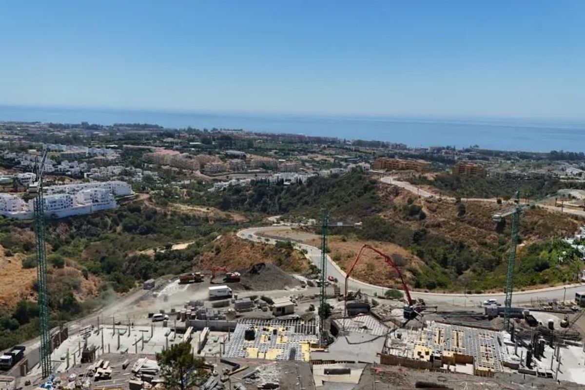 Brede luchtperspectief van Estepona, Costa del Sol, met bouwwerkzaamheden en omringend landschap.