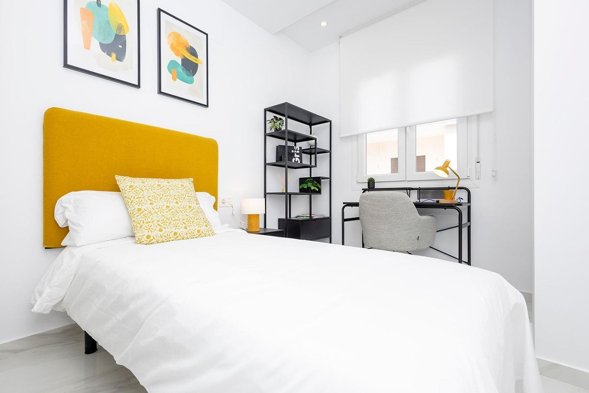 Gezellige eenpersoonskamer in het 2-slaapkamer appartement in Jacarilla, met een bureau en vrolijke decoratie.