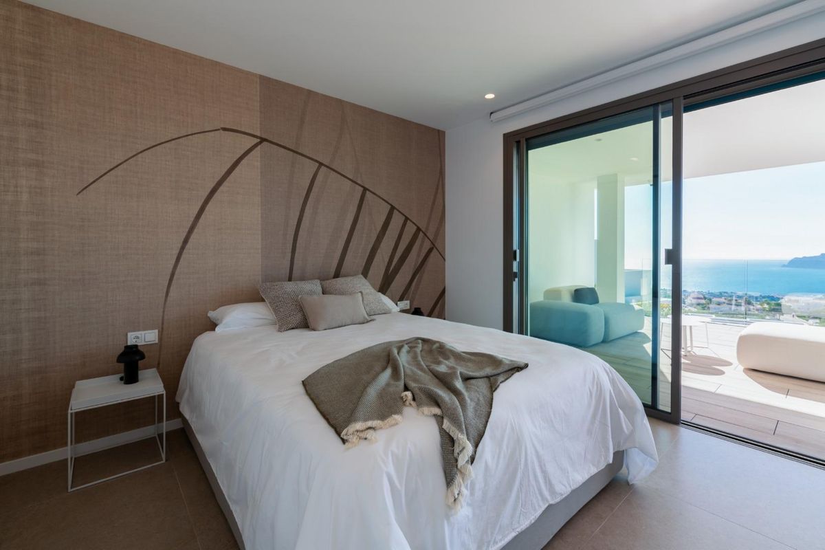 Charming bedroom in a 4-bed villa, featuring a cozy design and access to a private terrace in Benitachell.