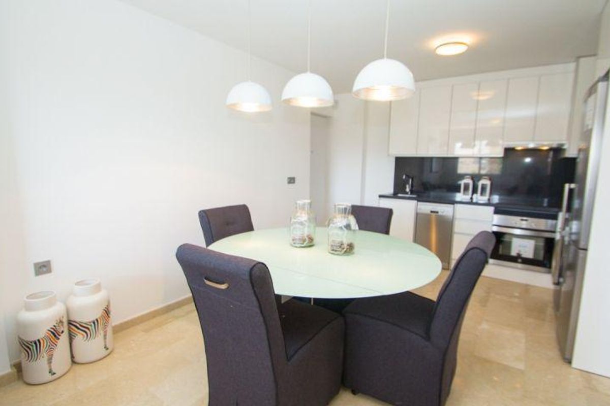 Moderne eetruimte in het appartement, met een ronde tafel en eigentijdse decoraties, ideaal voor vermaak.