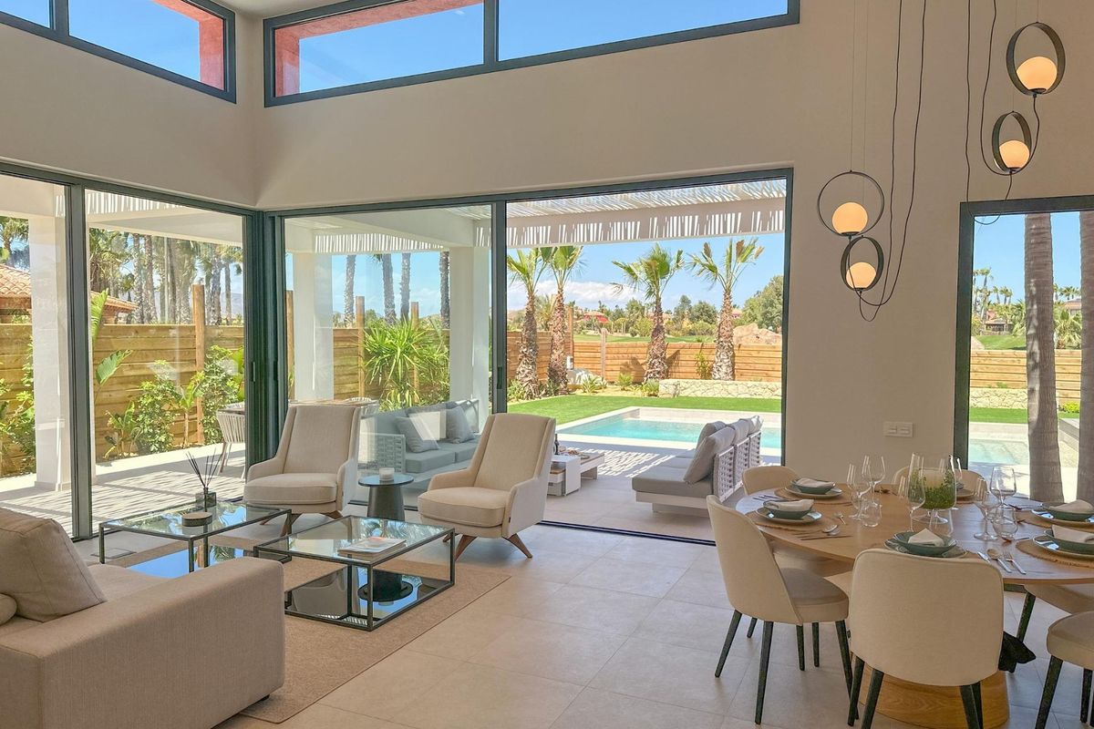 Ruimtelijke woonkamer en eetkamer in een villa in Cuevas Del Almanzora, verlicht door grote ramen naar het zwembad.
