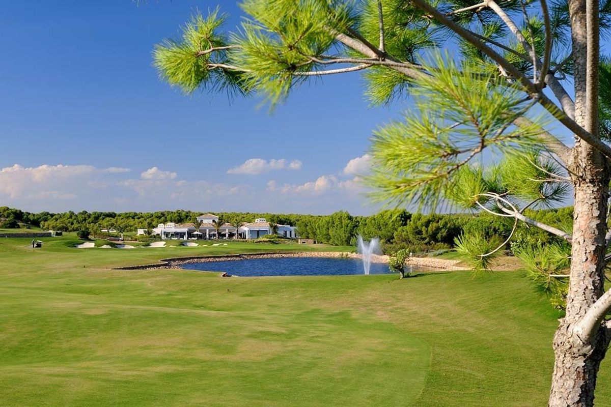 Prachtig panorama van een golfbaan met weelderige vegetatie en een schilderachtig meer, gelegen nabij Orihuela.