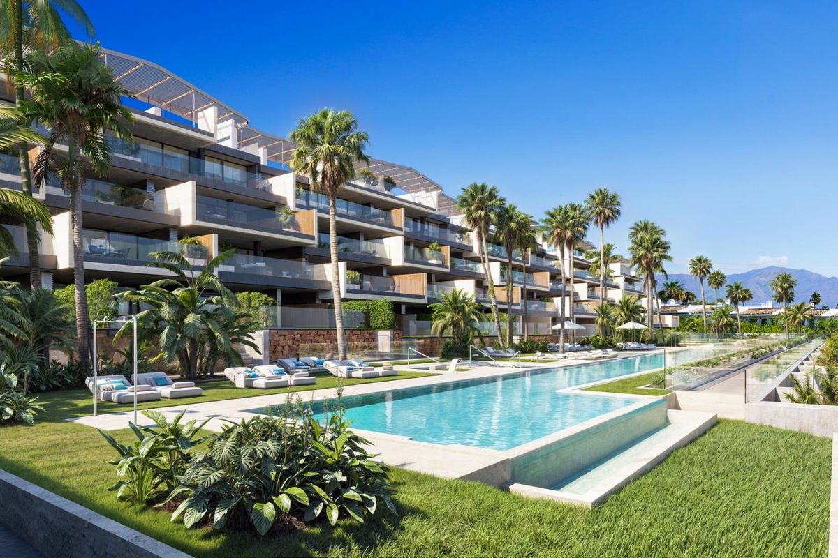 Stijlvol appartementencomplex met zwembad en palmbomen in Manilva, Costa del Sol.