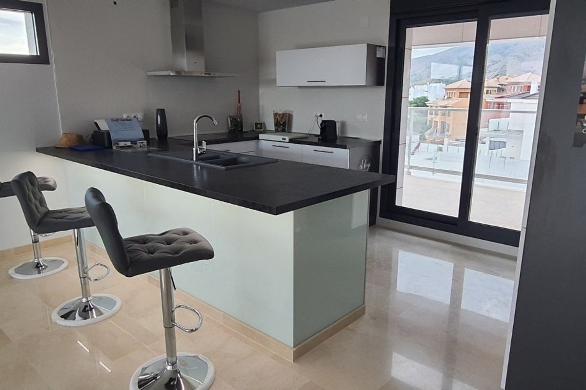 Stijlvol keukeneiland in de villa in Finestrat, geaccentueerd door natuurlijk licht en modern decor.