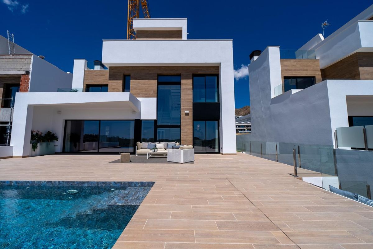 Uitzicht op de buitenkant van de villa met de infinity pool en moderne zitruimte in Finestrat, Costa Blanca Noord.