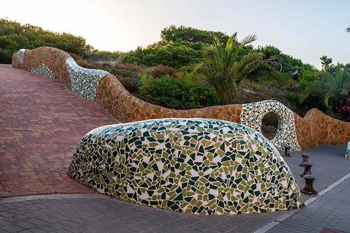 Mozaïek pad dat door tuinen in Guardamar del Segura leidt, met lokale flora.