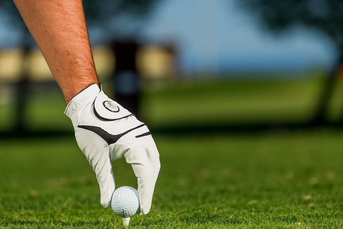 Close-up van een golfer die zich voorbereidt om af te slaan op een levendige golfbaan nabij Pilar de La Horadada.