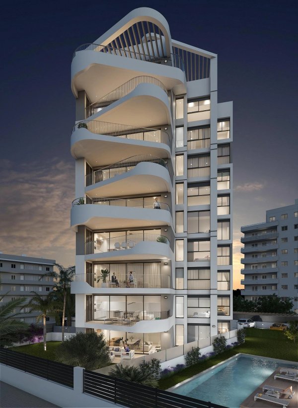 Modern 3-slaapkamer appartement gebouw in Guardamar del Segura, met unieke architectuur en avondverlichting.
