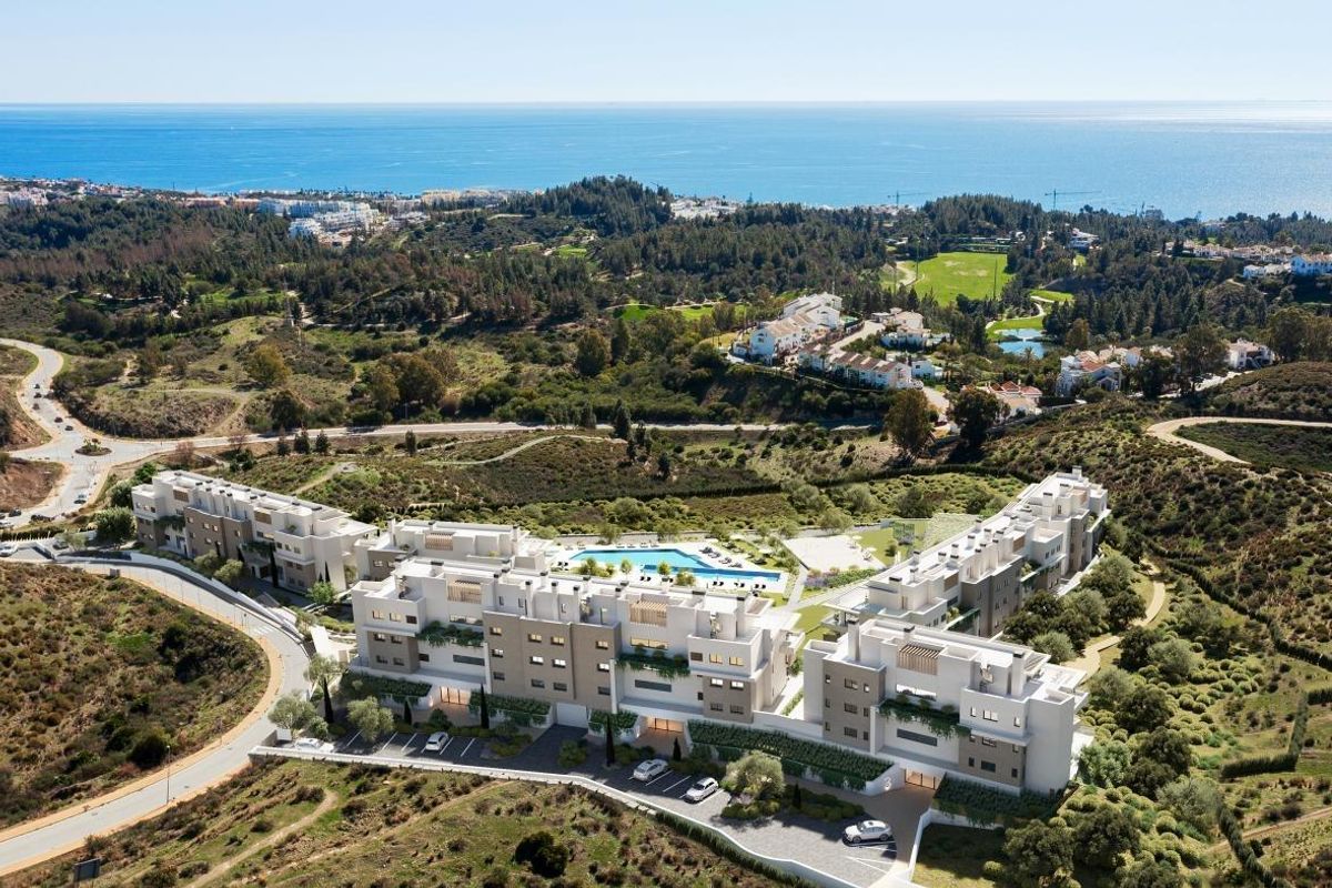 Luchtfoto van het moderne appartementencomplex in Costa del Sol, omringd door schilderachtige heuvels en groen.