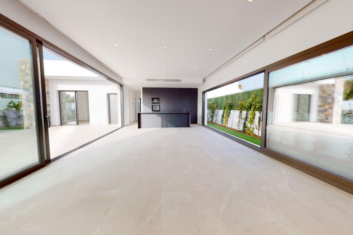 Interieurzicht op de open woonkamer en keuken, met grote ramen in de villa in Los Alcazares.