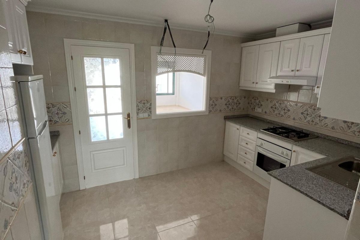 Heldere keukenruimte in het appartement op de begane grond, uitgerust met moderne voorzieningen in Orihuela Costa.