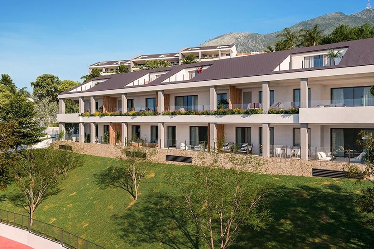 Buitenzicht van een gebouw op een heuvel met tuinen, waarin penthouses in Benalmádena, Costa del Sol.