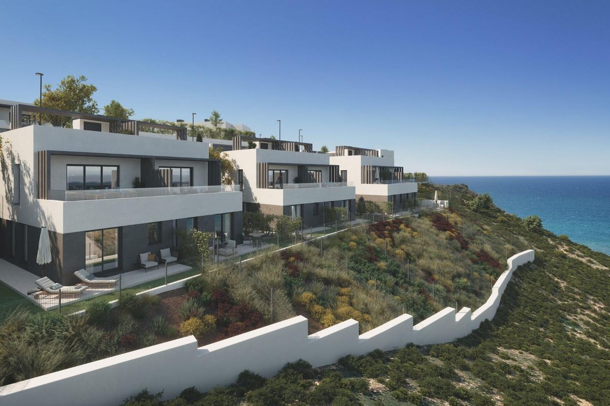 Zijaanzicht van moderne townhouses op een heuvel met prachtig uitzicht op de kust in Vélez Málaga, Costa del Sol.