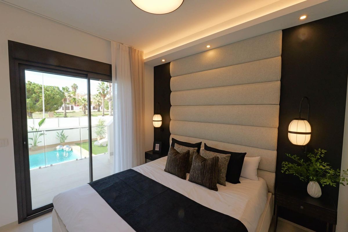 Chique slaapkamer met uitzicht op het zwembad en moderne meubels in een 3-slaapkamer villa in Costa Blanca.