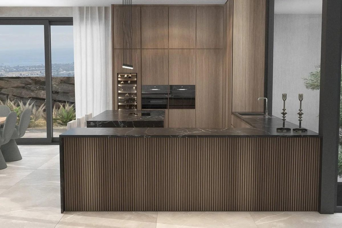 Strakke keuken met donkere kasten en een modern eiland, onderdeel van een villa in Benahavís, Costa del Sol.