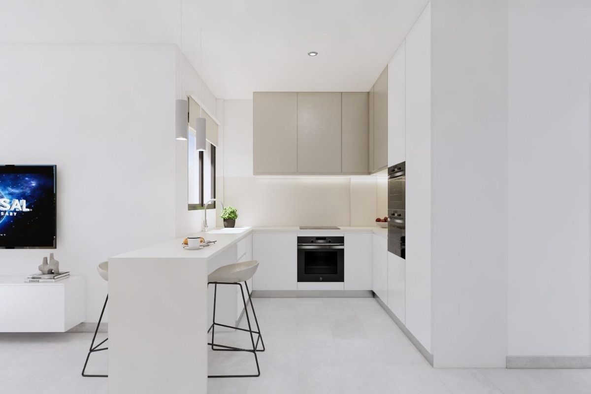 Strakke keuken met apparaten en een ontbijtbar in een hedendaagse villa in Los Alcazares.