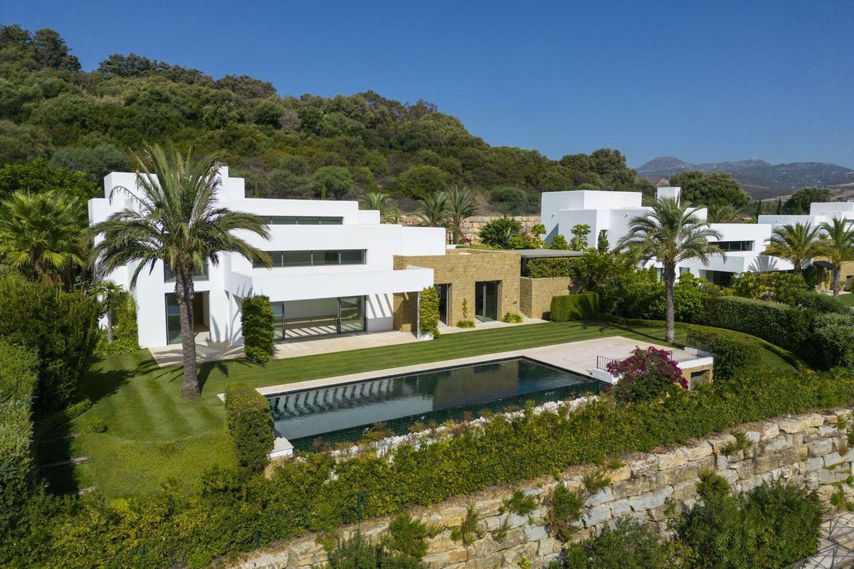Luchtperspectief van een stijlvolle villa in Casares met uitgebreide tuinen en een rustige zwembadzone.