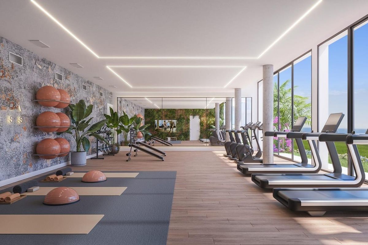Goed uitgeruste fitnessruimte vol natuurlijk licht en met uitzicht in een townhouse complex in Mijas.