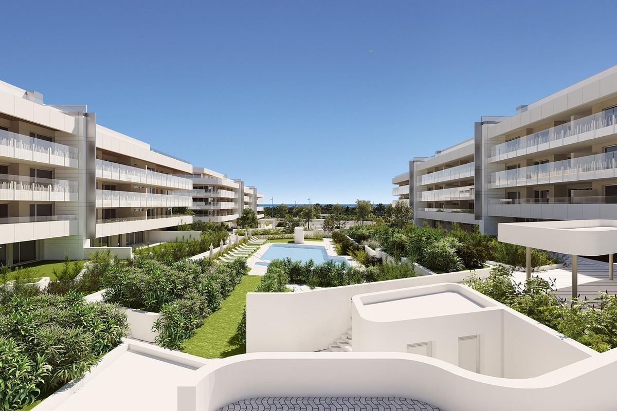 Overzicht van een modern appartementencomplex in Marbella met aangelegde tuinen en een zwembad.