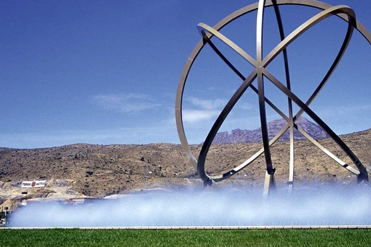 Contemporary beeldhouwwerk in de omgeving van Finestrat, omgeven door gras en bergen op de achtergrond.