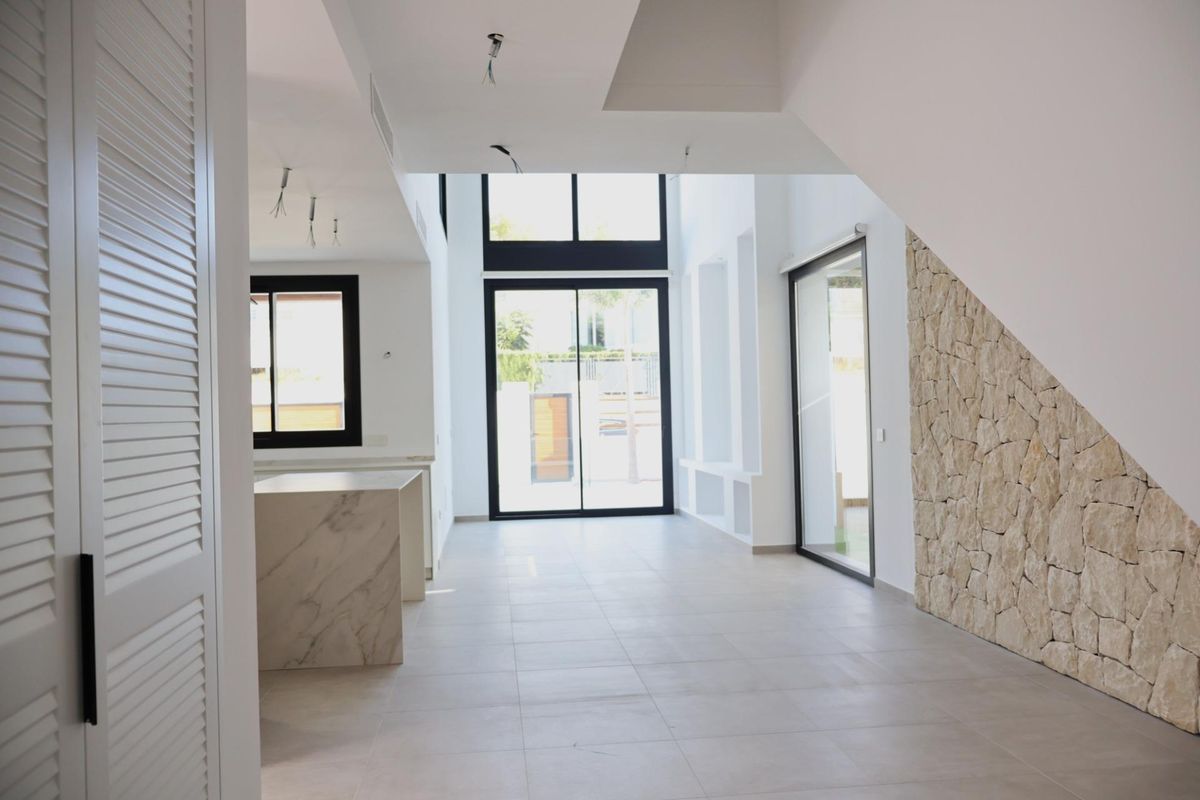 Ruimtelijke woonkamer binnen de villa in Alfas del Pi, met grote ramen en moderne ontwerp elementen.