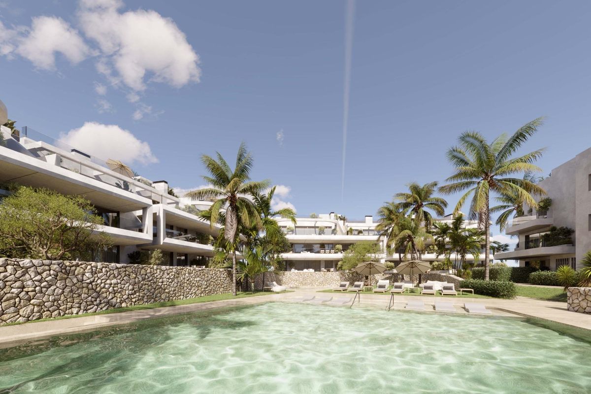 Uitzicht op een resortachtige zwembad omringd door palmbomen in Estepona, Costa del Sol.