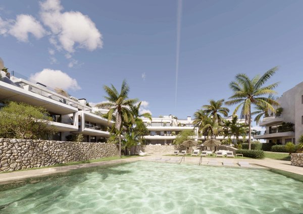 Uitzicht op een resortachtige zwembad omringd door palmbomen in Estepona, Costa del Sol.