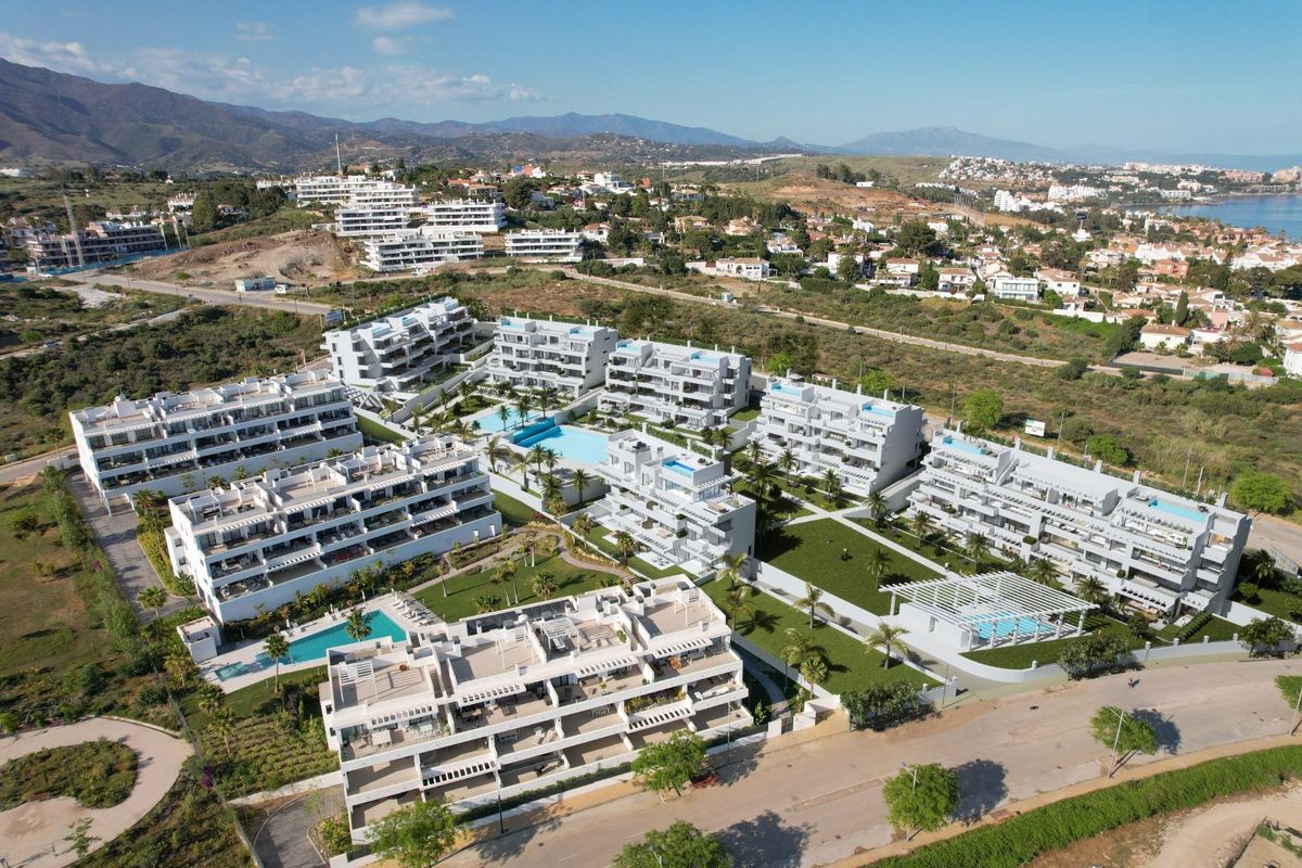 Panoramisch uitzicht op Estepona met meerdere woongebouwen en een bergachtige achtergrond.