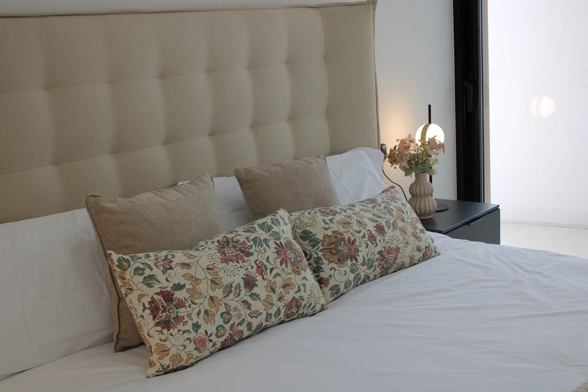 Gezellig bed met decoratieve kussens in een chique slaapkamer van een 3-slaapkamer villa in Pilar de La Horadada.