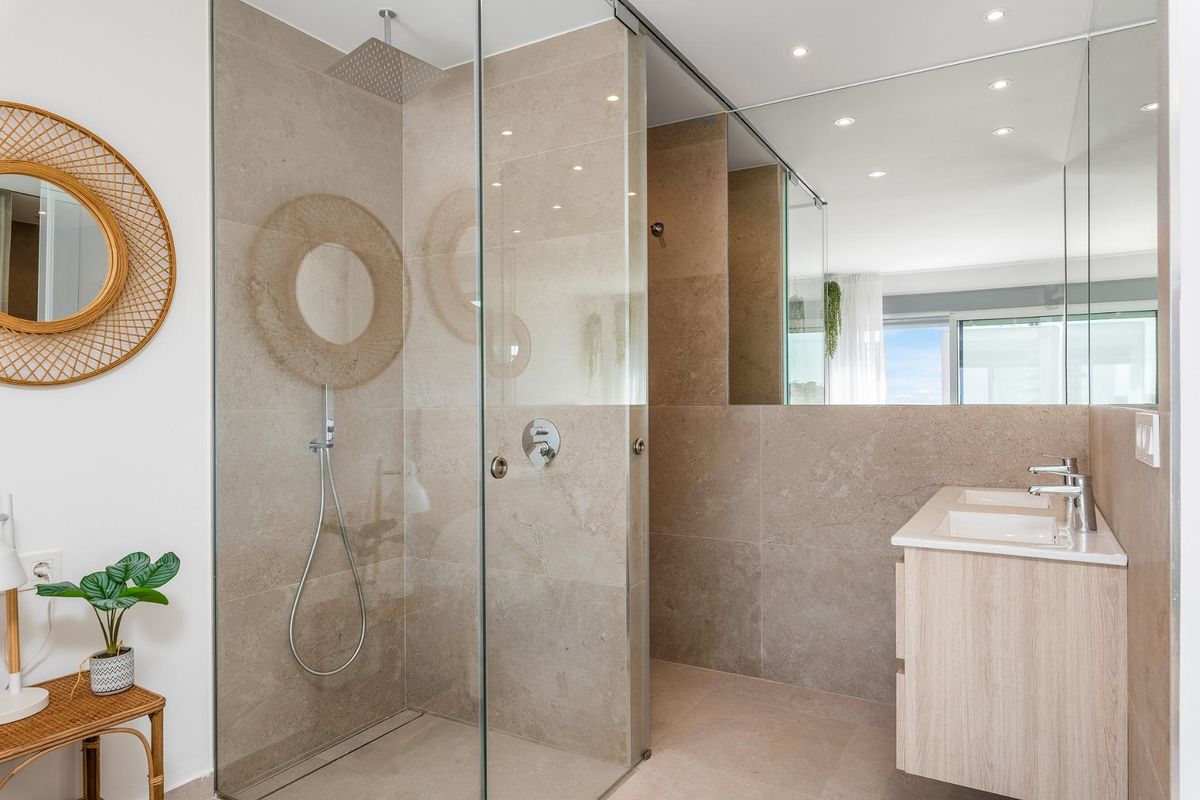 Modern badkamer met glazen douche en stijlvolle afwerkingen in een 3-kamerappartement op de begane grond in Dolores.