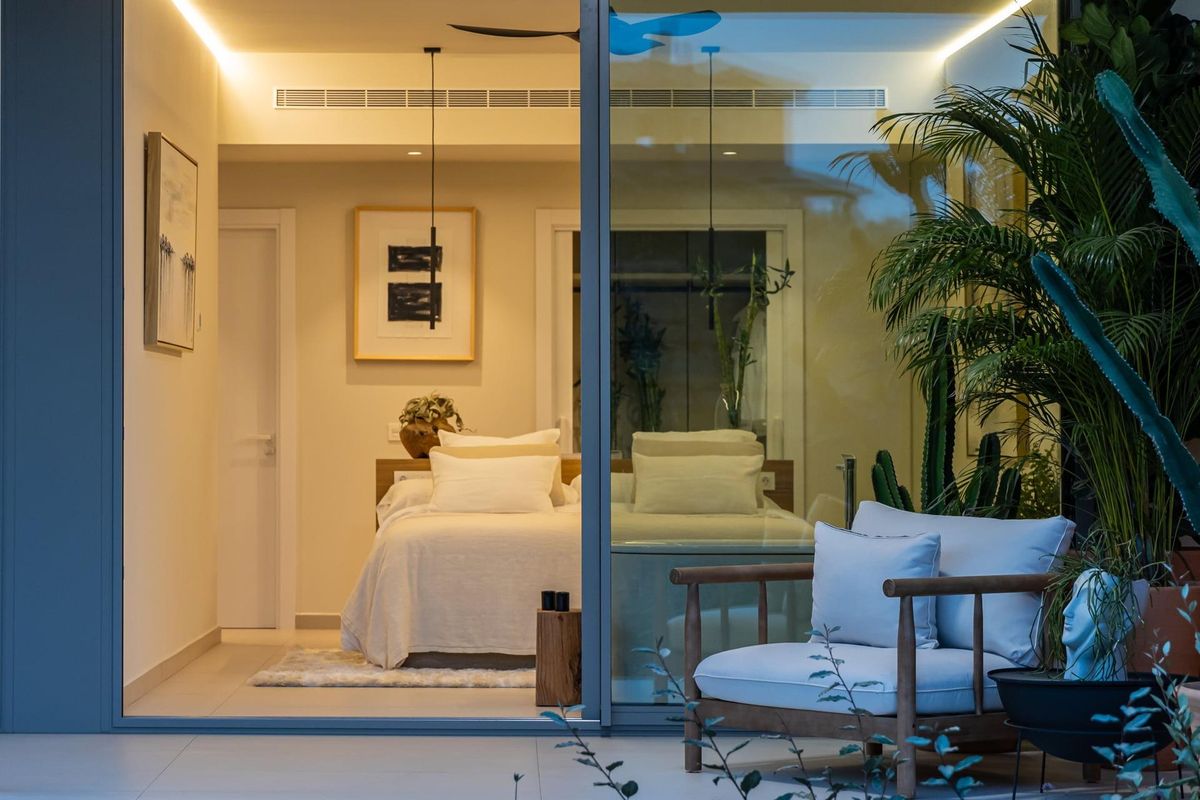 Stijlvolle slaapkamer met moderne inrichting en warme verlichting in het appartement in Fuengirola.