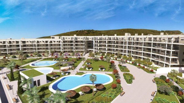 Aerial view of a modern complex with pools and gardens in Manilva, Costa del Sol, featuring 2-bed apartments.