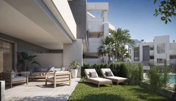 Begane grond terras met loungestoelen in Estepona, Costa del Sol, omringd door palmbomen.