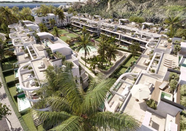 Luchtfoto van een modern appartementencomplex in Estepona, met weelderige tuin en zwembaden.