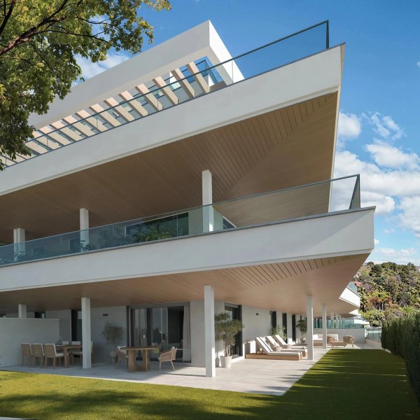 Moderne buitenaanzicht van een nieuw appartementencomplex in Estepona, met ruime terrassen en groen.