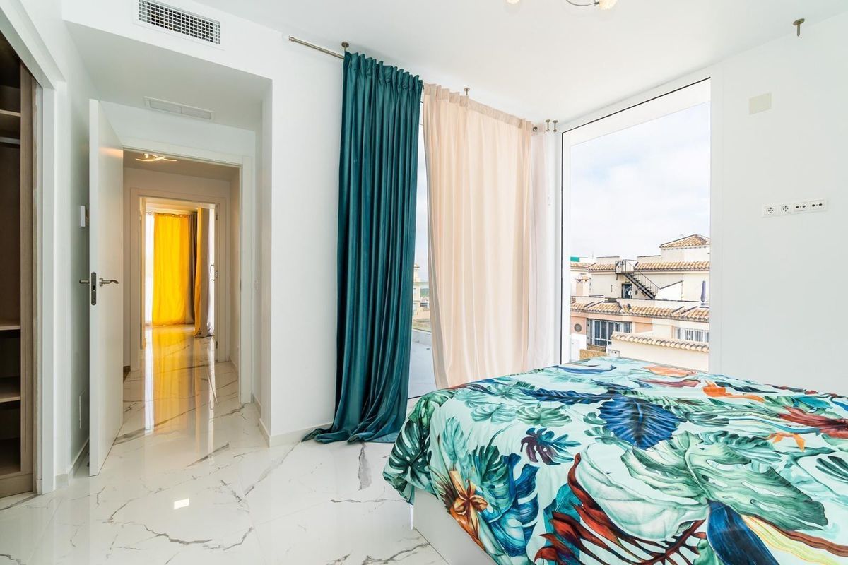 Vibrant bedroom inside the three-bedroom villa in Orihuela Costa, featuring floral decor and natural light.