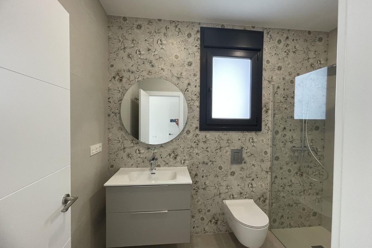 Elegante badkamer met bloemmotief behang en een moderne wastafel, gelegen in de villa in Rojales.