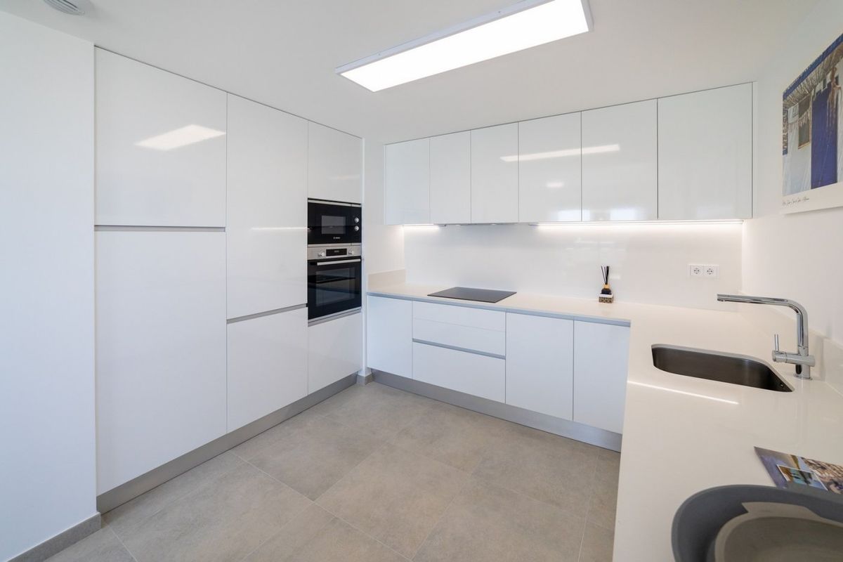 Minimalistisch keukenontwerp met veel opslagruimte in een 3-slaapkamer appartement in Santa Pola, met een strakke ambiance.