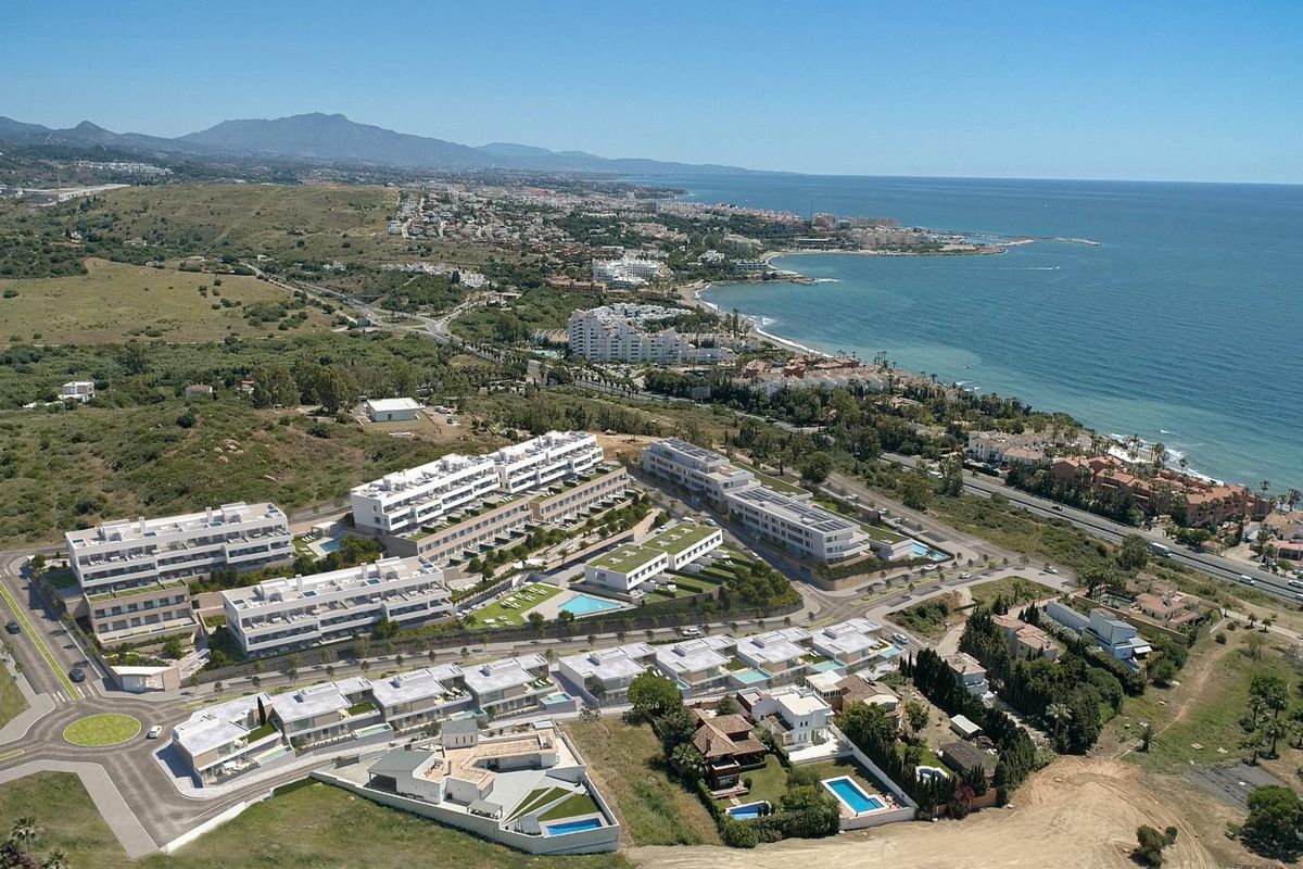 Luchtfoto van een luxe woningcomplex in Estepona, met villa's en kustlandschap.