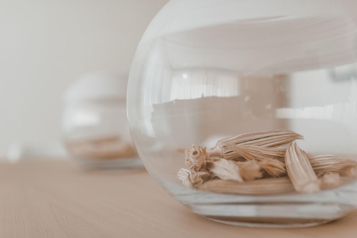 Close-up van decoratieve elementen in een appartement in Benahavís, met stijlvolle glazen containers en natuurlijke decoratie.