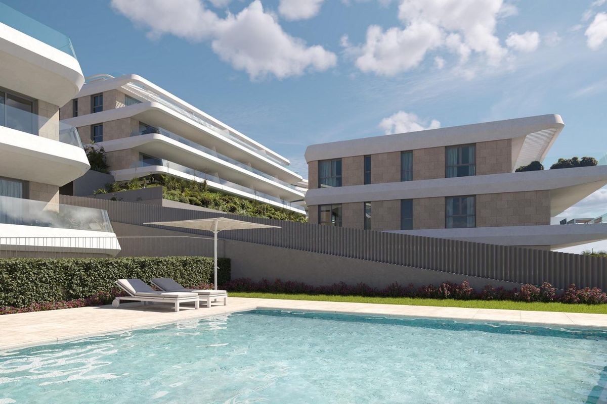 Uitnodigend zwembad omringd door goed onderhouden tuinen en moderne appartementen in Estepona, Costa del Sol.