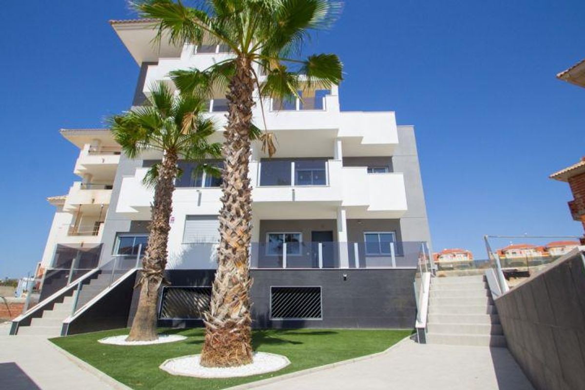 Buitenkant van een modern appartementencomplex met palmbomen in Orihuela Costa, Spanje.