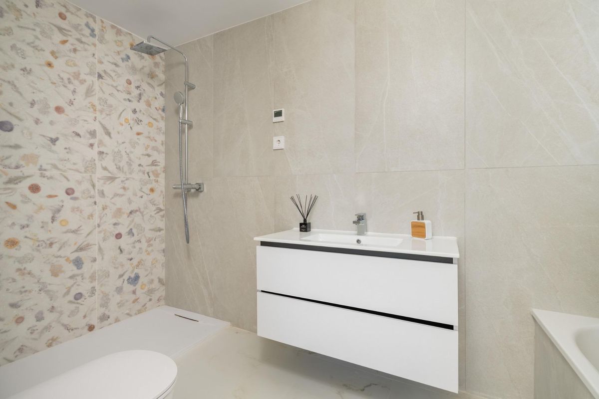 Stijlvolle badkamer met uniek behang in het penthouse in Estepona, compleet met moderne armaturen.