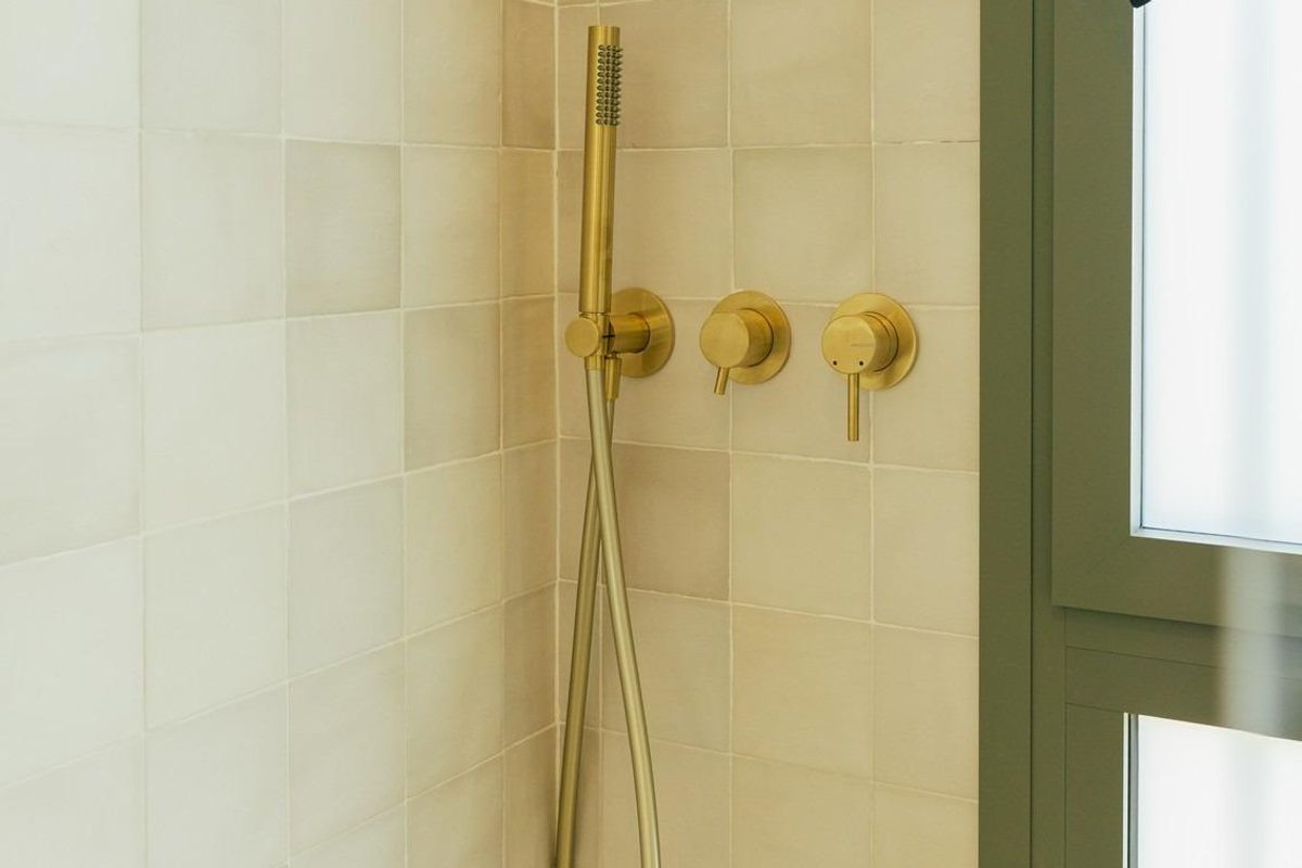 Elegante douchehoek met gouden armaturen in een moderne badkamer van een 3-slaapkamer villa in Jávea Xàbia.