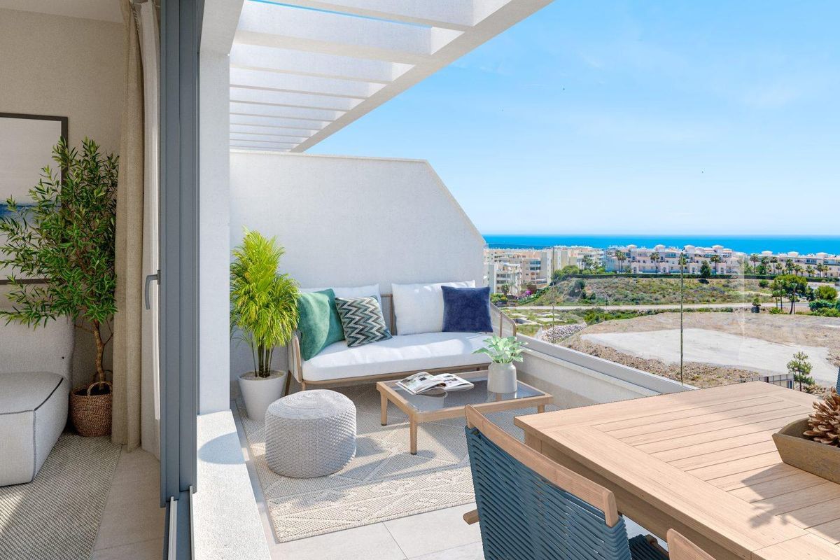 Ruimtelijk terras met zitplaatsen en uitzicht op de kust in een 2-slaapkamer appartement in Mijas, Costa del Sol.